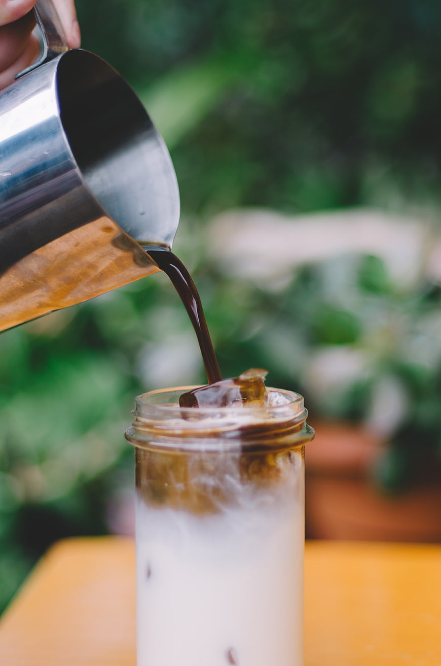 Pouring Iced Coffee into Glass with Milk