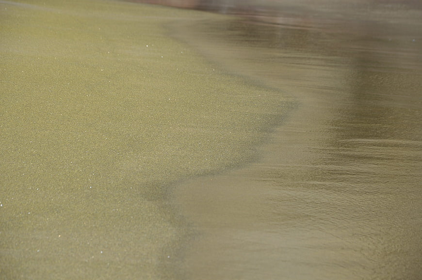 Close-up of wet sand texture on a beach shoreline