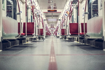 Empty subway car interior with red seats and leading lines
