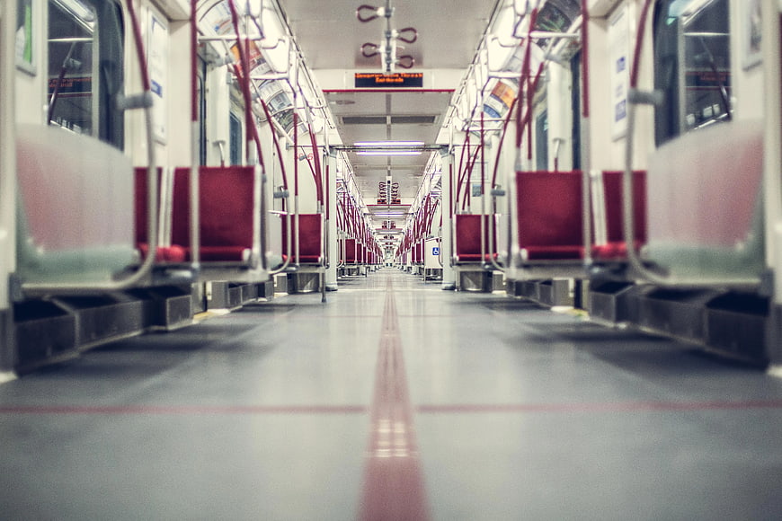 Empty subway car interior with red seats and leading lines