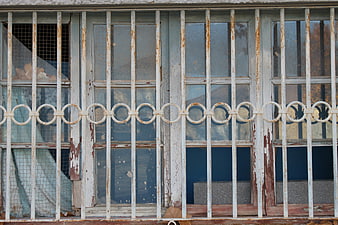 Rusty metal bars on an old weathered window frame