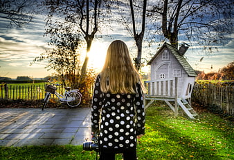 Girl with Camera in Garden at Sunset