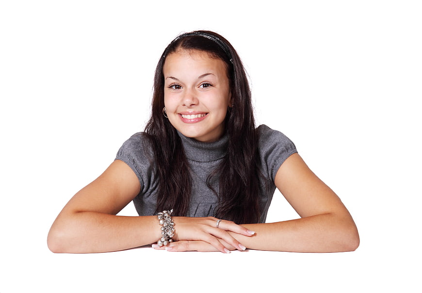 Smiling teenage girl with dark hair on white background