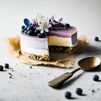Layered Blueberry Cheesecake with Edible Flowers and Golden Spoon