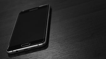 Black Smartphone on Dark Wood Table