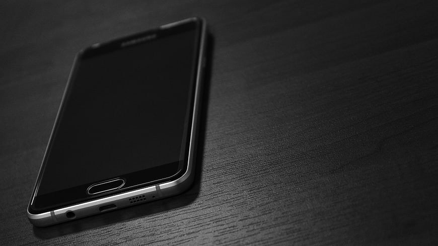 Black Smartphone on Dark Wood Table