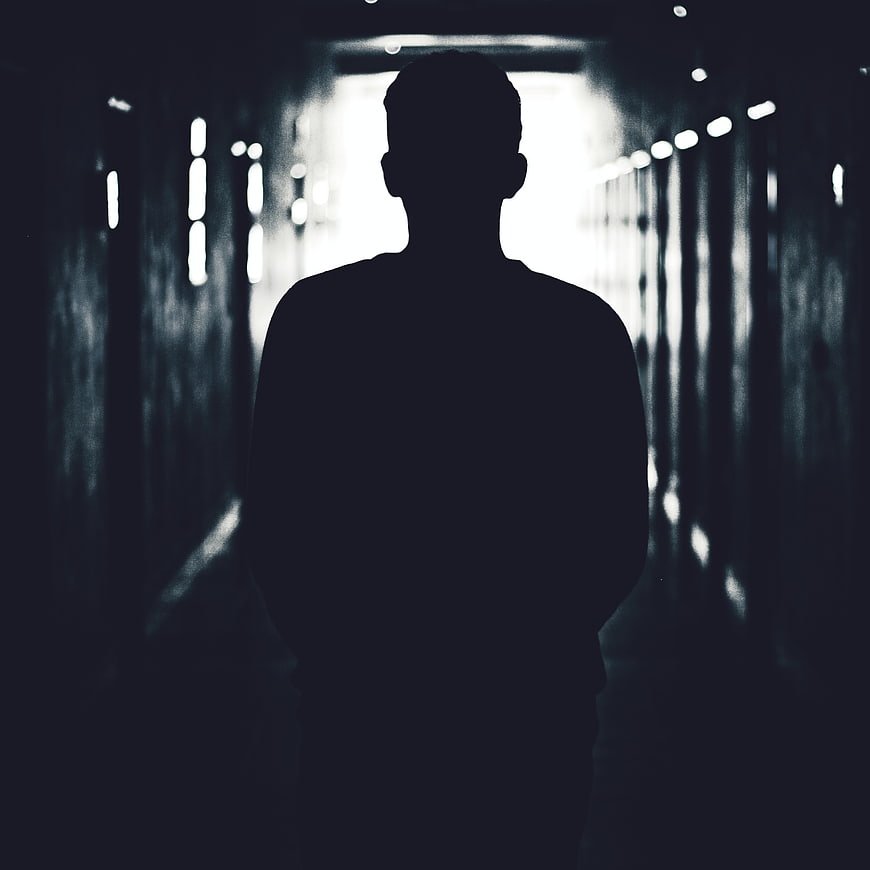 Silhouette of a man standing in a dark tunnel