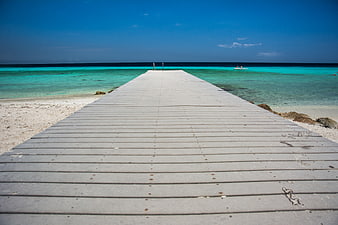Wooden Pier Extending Into Turquoise Tropical Ocean