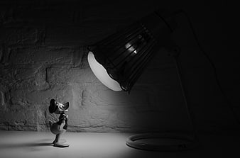 Black and white Donald Duck figurine under desk lamp