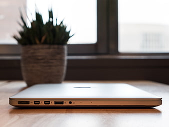 Side View of Closed Silver Laptop on Wooden Desk