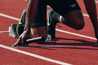 Athlete in Starting Blocks on Red Running Track