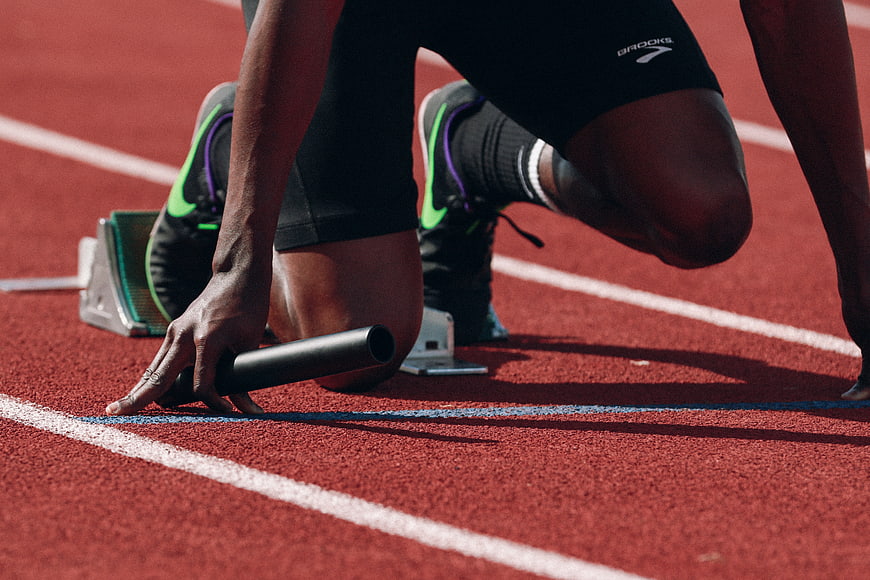 Athlete in Starting Blocks on Red Running Track
