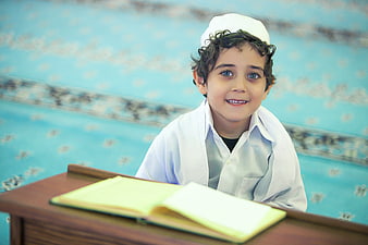 Young Boy in White Cap Studying at a Desk