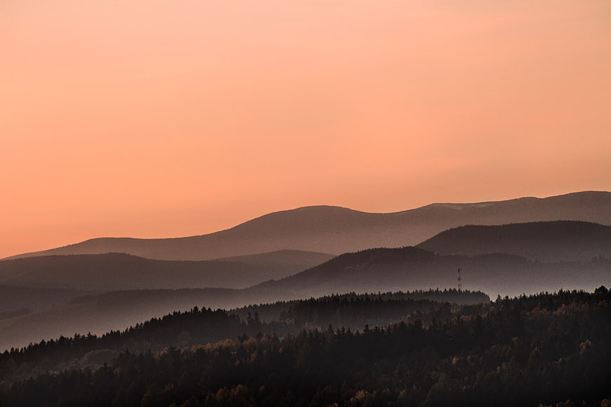 Serene Mountain Landscape at Sunset with Misty Forest Layers