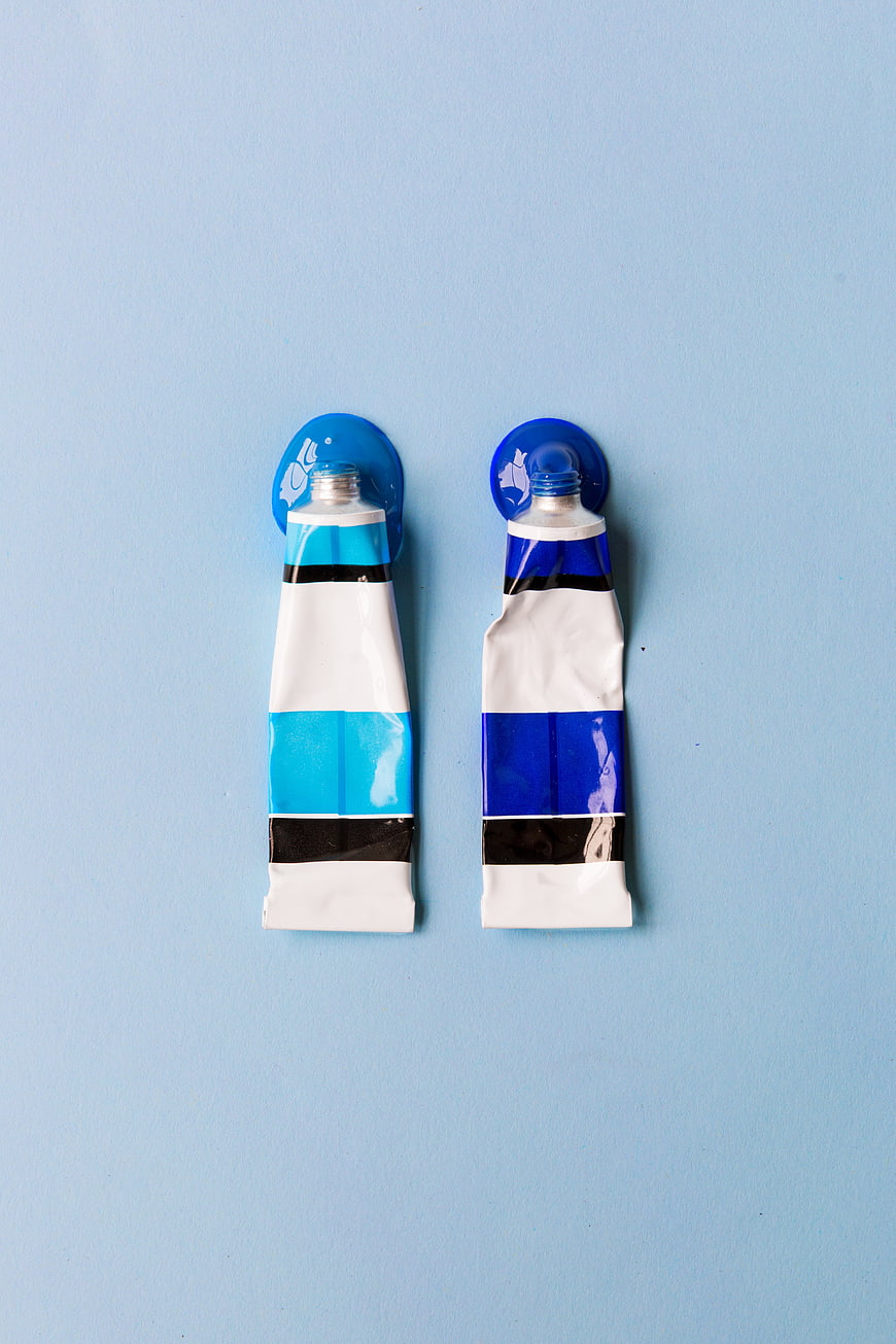 Two Blue Paint Tubes Flat Lay on Light Blue Background