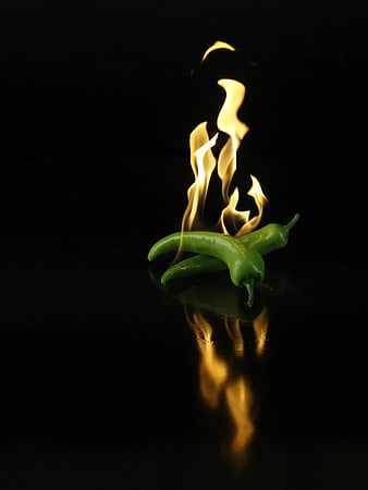 Green Chilies with Fire on Black Background