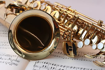 Close-up of golden saxophone on sheet music