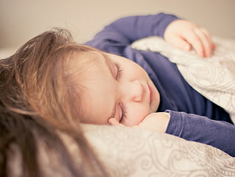 Close-up of sleeping toddler girl on patterned pillow