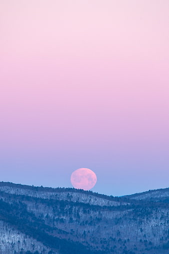 Pink Supermoon Rising Over Snowy Mountain Landscape