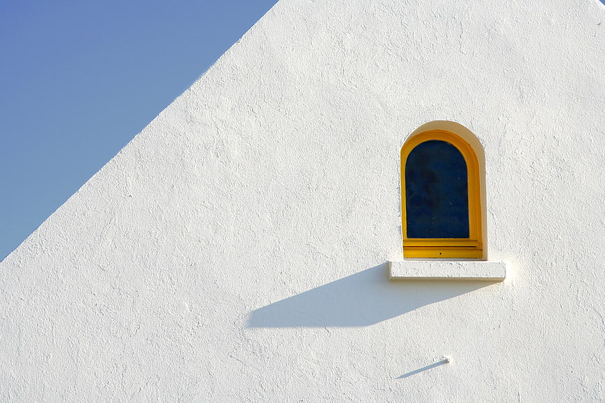Minimalist White Wall With Yellow Arched Window And Blue Sky