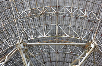 Industrial metal dome structure with steel trusses and geometric patterns