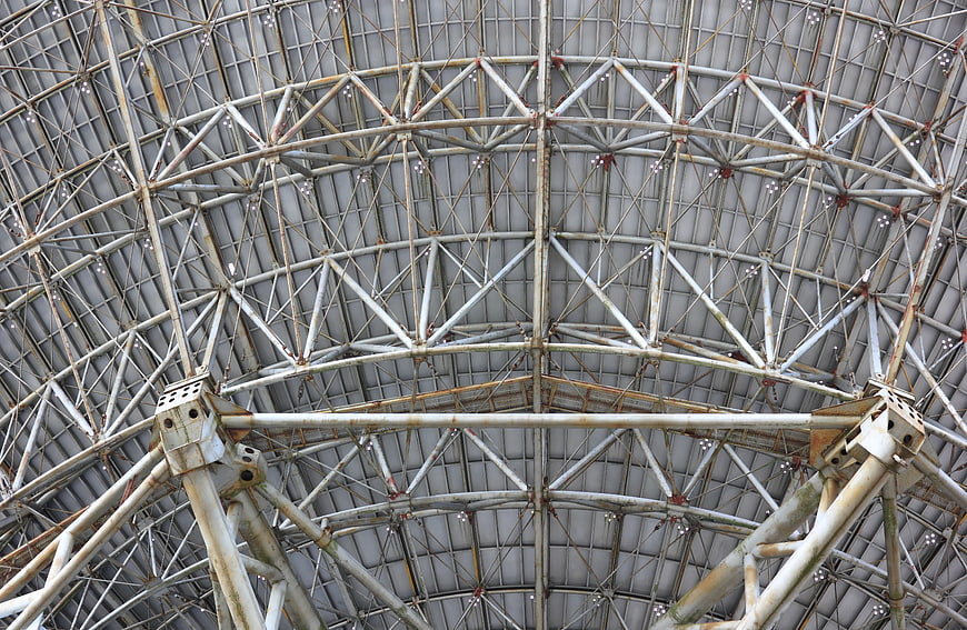Industrial metal dome structure with steel trusses and geometric patterns
