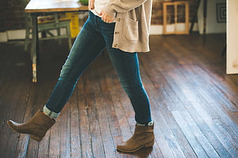 Woman Walking in Jeans and Brown Boots on Wooden Floor