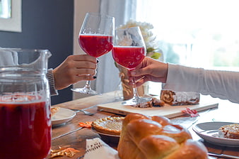 Two people toasting with red wine at a festive autumn table