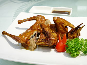 Crispy Roasted Pigeon Dish With Garnish On White Plate