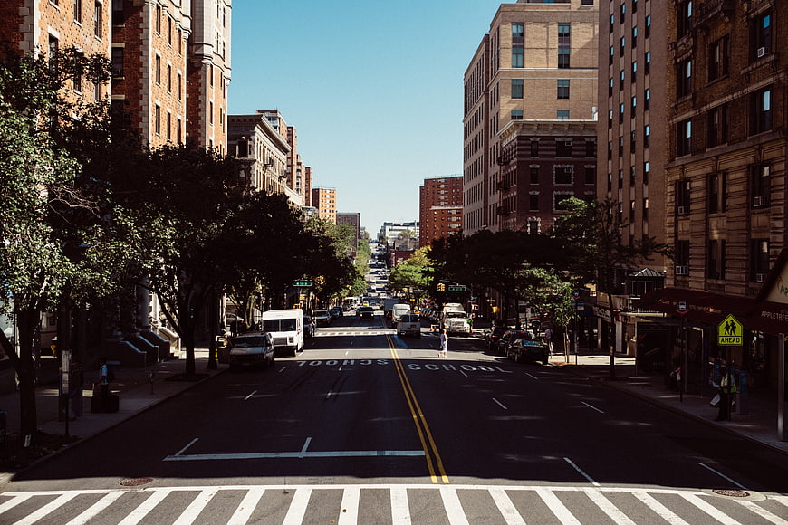 Sunny urban street view with school zone markings and brick buildings