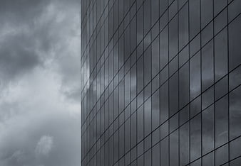Modern Glass Skyscraper Facade Against Stormy Clouds