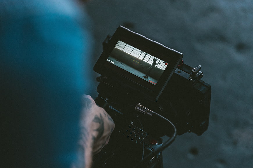 Cinematographer filming scene with professional camera monitor