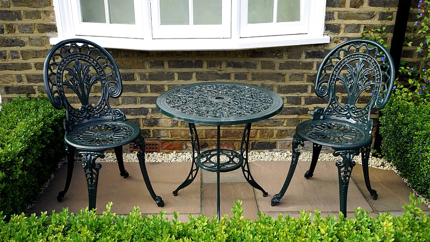 Green Cast Iron Garden Furniture Set on Paved Patio