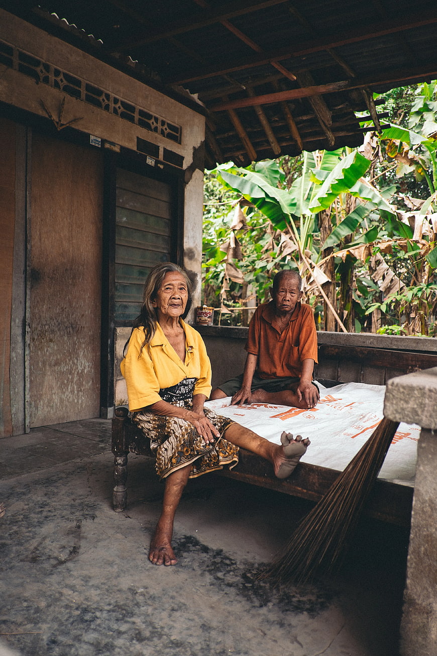 Elderly Couple Sitting on Porch in Rural Village