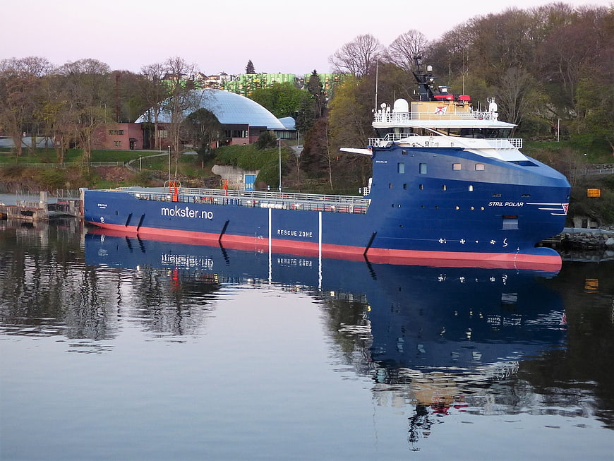 Blue research vessel Stril Polar docked in calm harbor