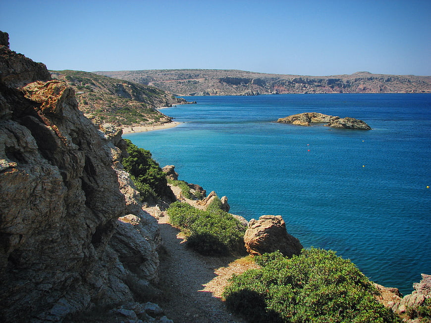 Scenic coastal path overlooking turquoise bay and rocky cliffs