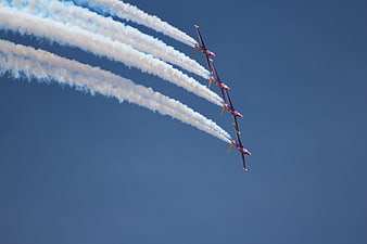 Red Aerobatic Jets in Formation with White Smoke Trails