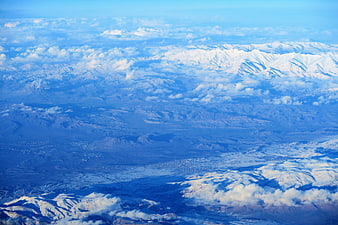Aerial View of Snow-Capped Mountains and Clouds