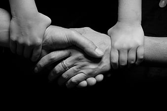 Black and white photo of adult and child hands holding