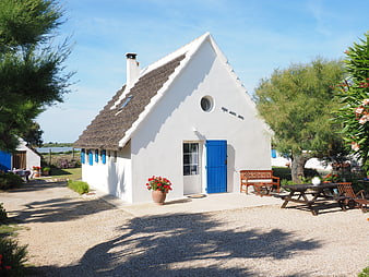 White Thatched Cottage With Blue Door In Camargue France