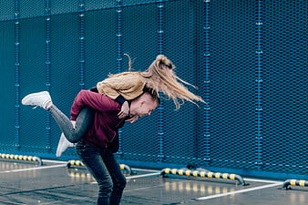 Happy couple piggyback ride on blue parking structure