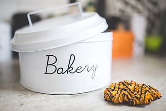 White metal bakery tin with chocolate drizzled cookie