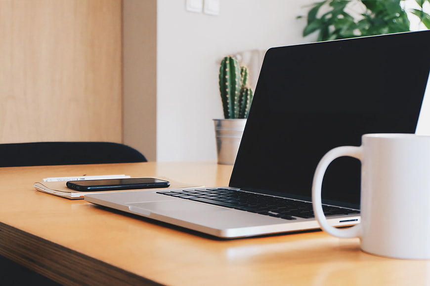Modern Workspace with Laptop, Coffee Mug, and Smartphone
