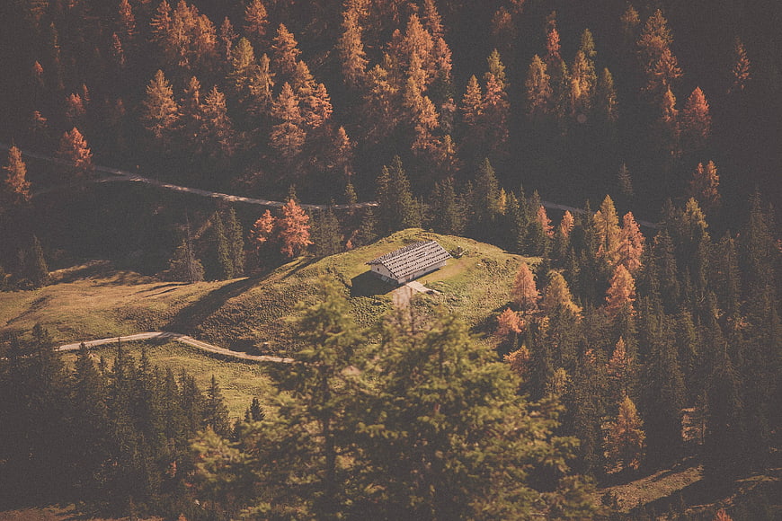 Aerial view of a solitary cabin in an autumn mountain forest