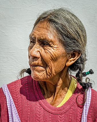 Portrait of elderly woman with deep wrinkles and braided hair