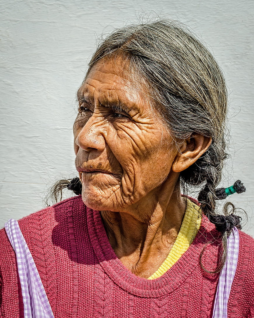 Portrait of elderly woman with deep wrinkles and braided hair