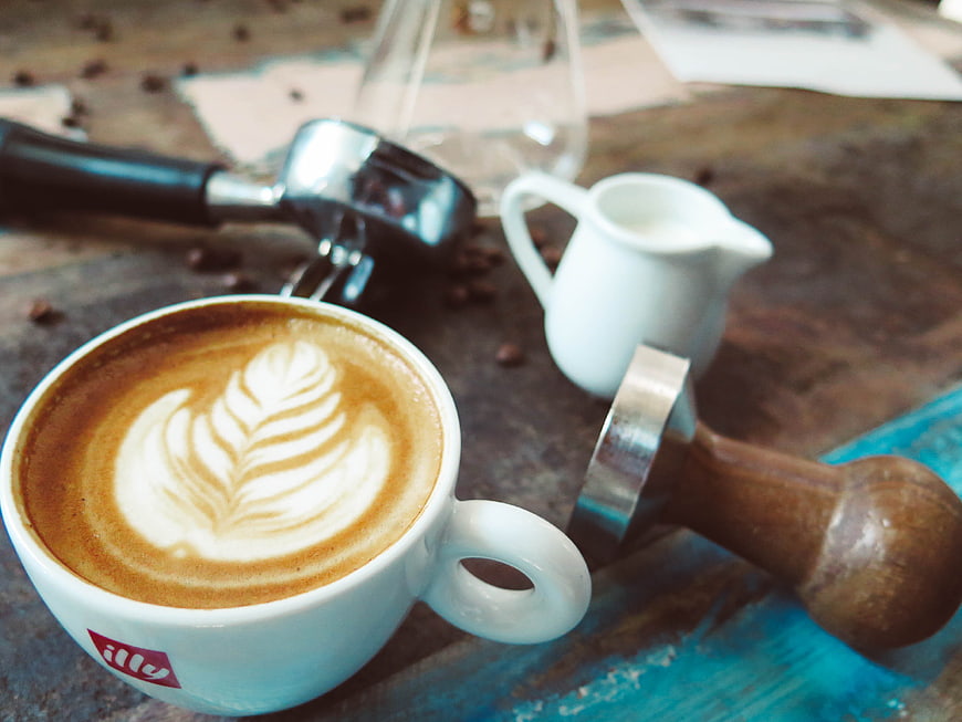 Latte Art Coffee Cup with Barista Tools on Rustic Table