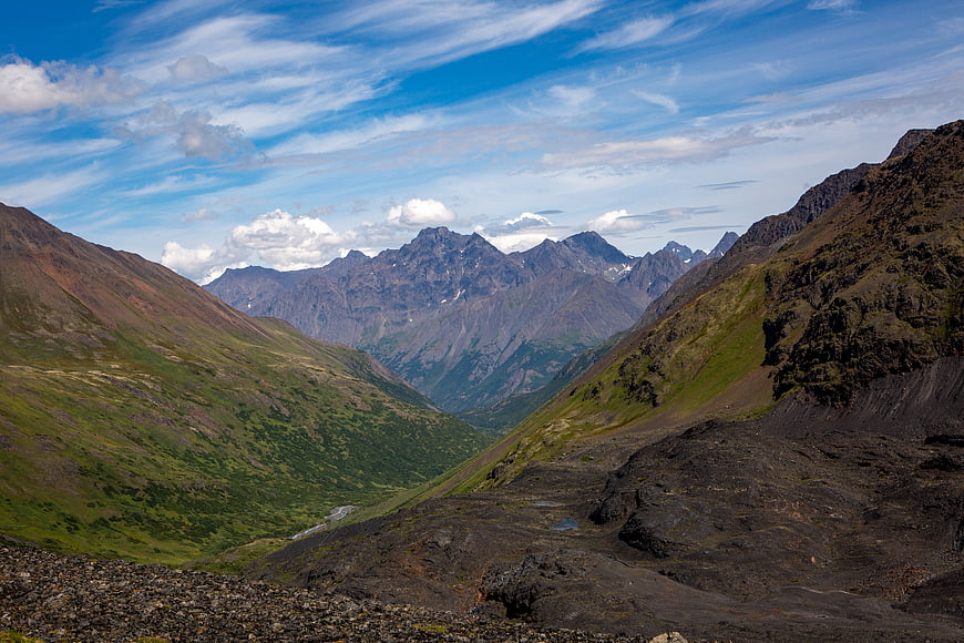 Panoramic Mountain Valley with Rocky Foreground and Blue Sky