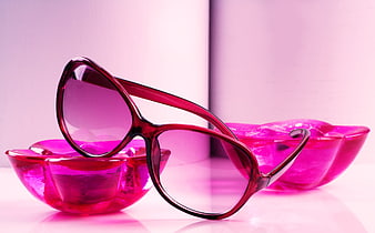 Pink sunglasses resting on translucent glass bowls