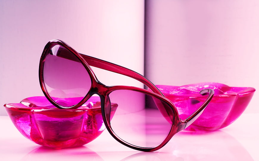 Pink sunglasses resting on translucent glass bowls